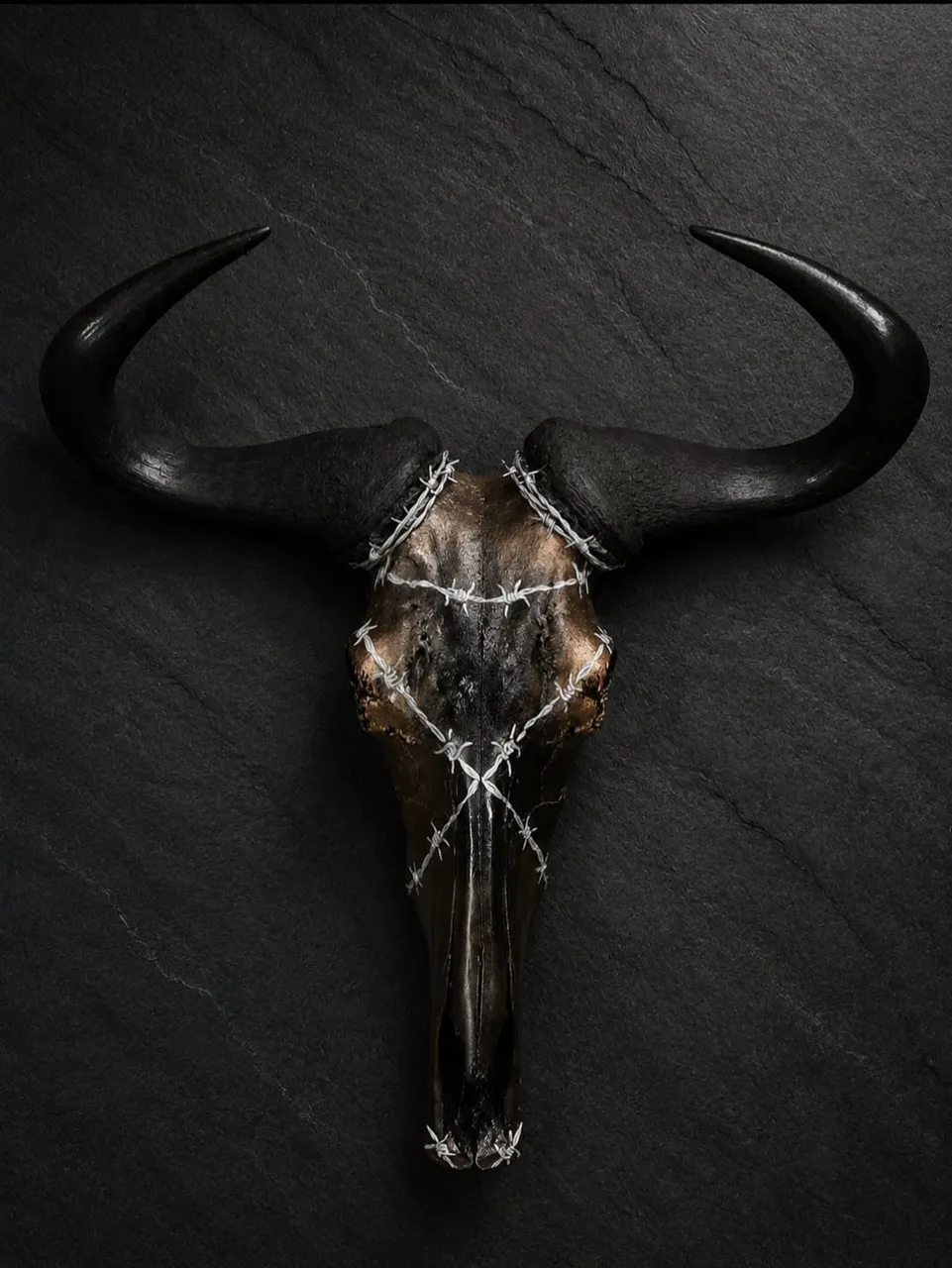 Blue wildebeest skull in bronze and black, wrapped with barbed wire accents, with sweeping black horns