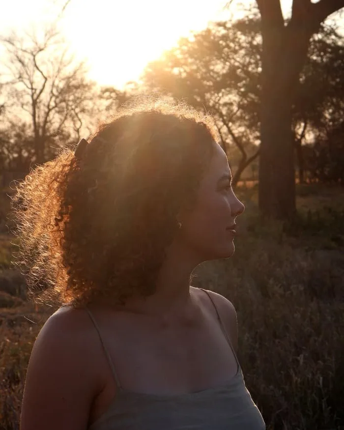 Portrait of Daleen of Krulle Kuns, in profile against a sunset and a bare tree