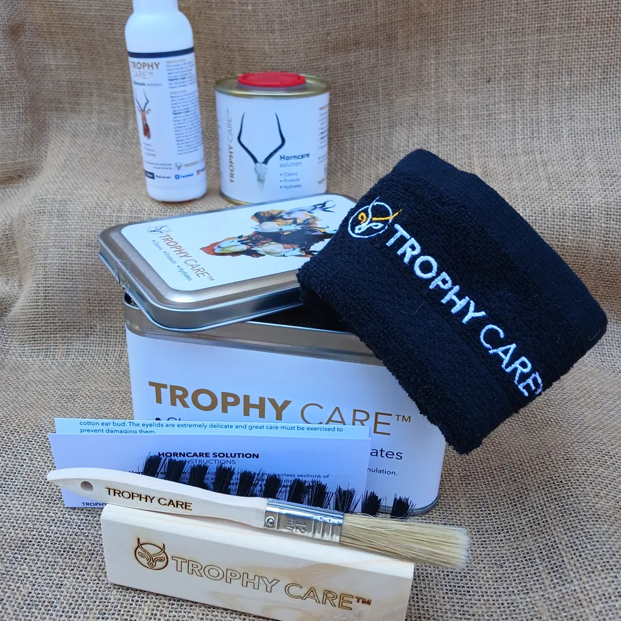 Trophy Care Value Pack laid out on hessian — branded tin, Skincare Solution, Horncare Solution, dusting brush, application brush, cloth and instruction leaflet